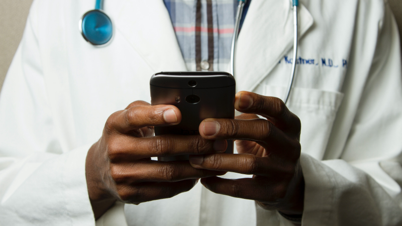 A doctor looking at a cellphone screen