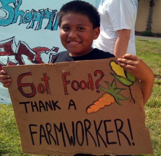 Child holding sign promoting farmworkers