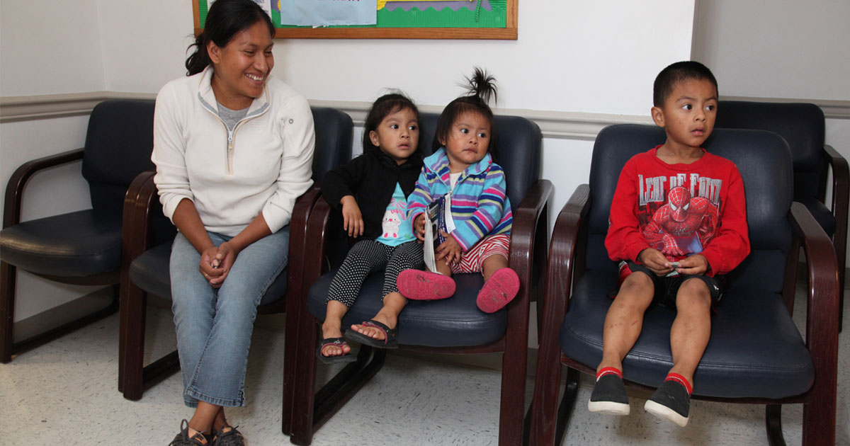 Mother and three children in clinic waiting room