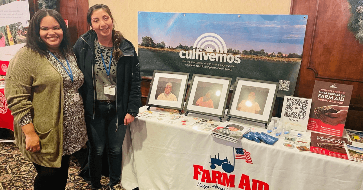 Jessica and Leslie stand at Farm Aid table