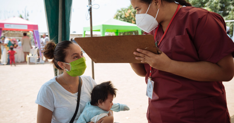 Nurse speaks with woman and child