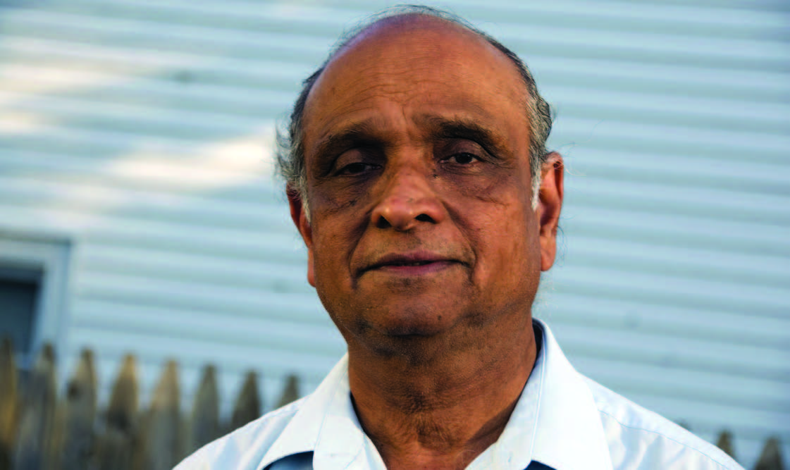 A migrant man poses for photo