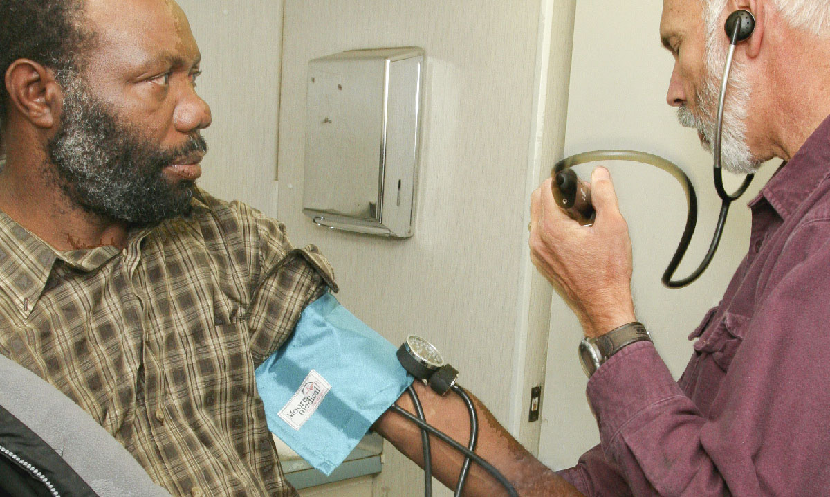 Doctor takes blood pressure of agricultural worker