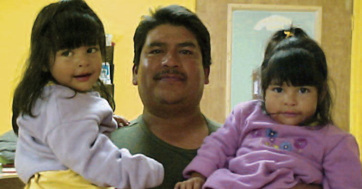 man holding two kids