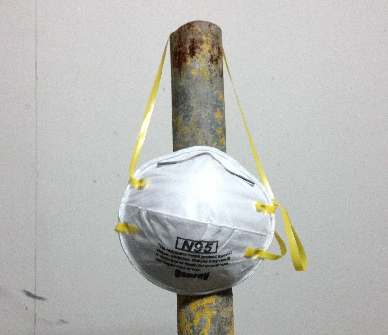 An N95 mask hanging on a pole. Photo by Kai Hendry.