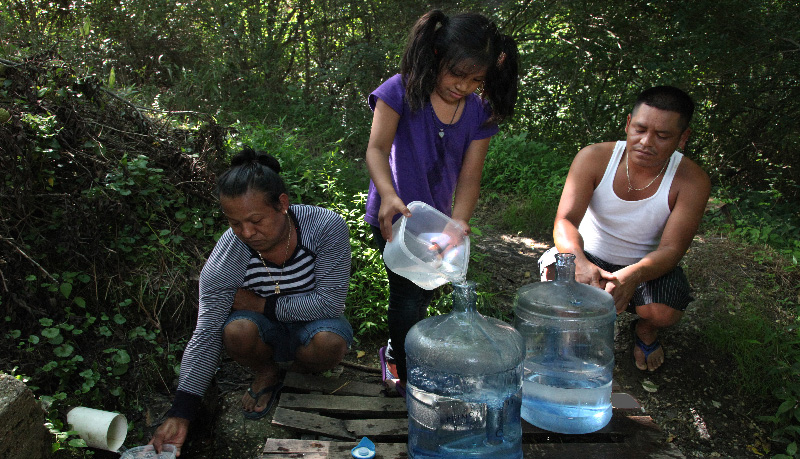 A family collecting water at a labor camp