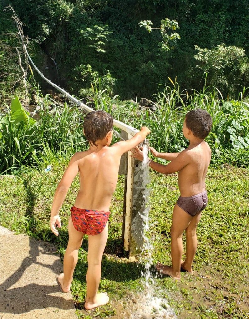 Kids play with water spout in Maricao camp