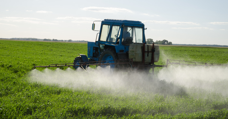 A vehicle spraying pesticides on a field