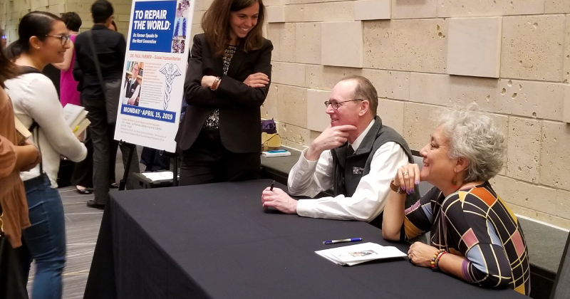 Dr. Paul Farmer, seated with MCN’s Deliana Garcia, at University of Texas in 2019.