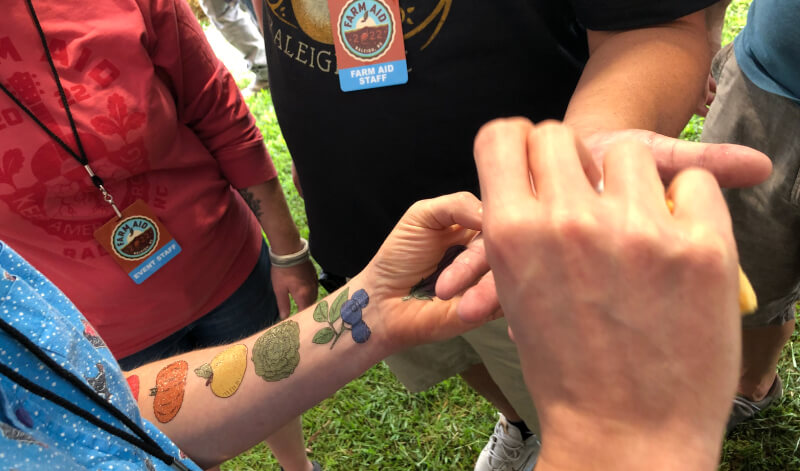 Staff provide temporary tattoos of fruit to attendees