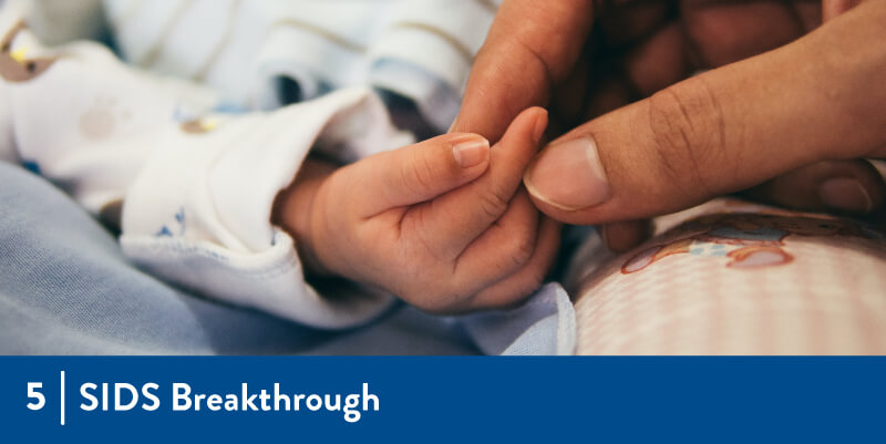 A mother holding an infant hand