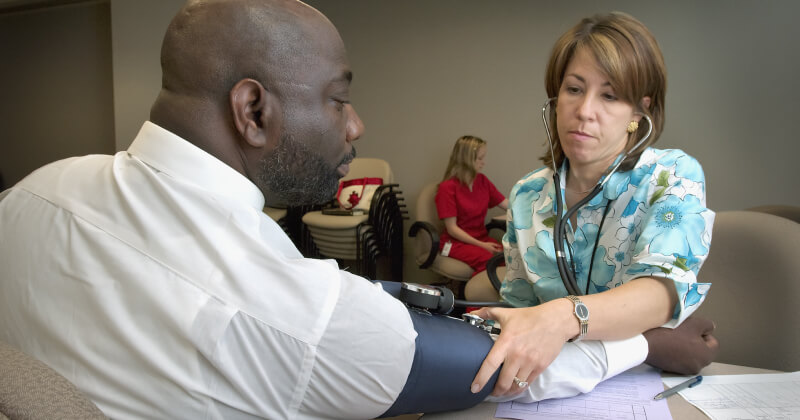 A clinician checks the blood pressure of a patient