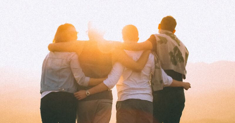 A group putting their arms around each other