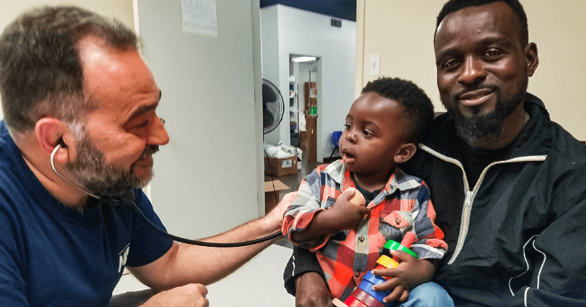 Dr. Laszlo Madaras provides care to child and father