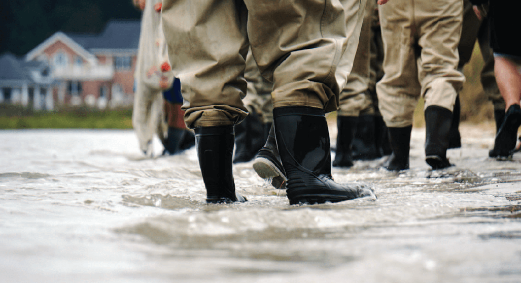 People in boots walking in flooding