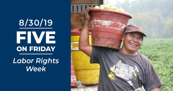 A smiling farmworker with bucket of tomatoes