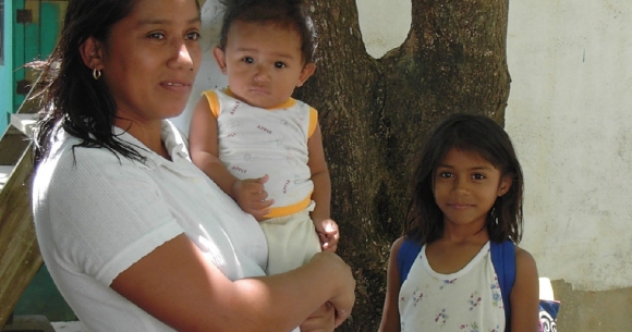 Woman stands with her baby and daughter