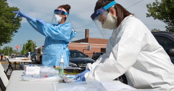 Clinicians put on PPE to prepare for outreach and testing