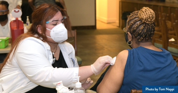 A clinician vaccinates a patient