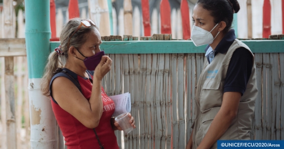 A CHW speaking with someone wearing a mask
