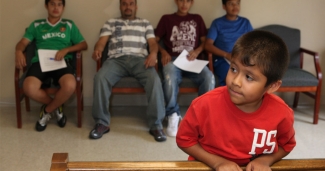 young boy and farmworkers in waiting room