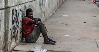 homeless man sitting on street corner