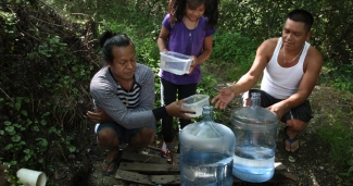 Family gathers water in forest