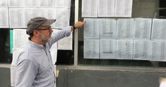 Mike Seifert points at lists of names of those waiting to be called to cross border legally