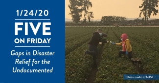 A farmworker hands another worker an N95 mask for the smoke