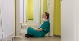 A doctor sits exhausted in hospital