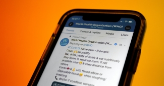 A cell phone showing the WHO facebook page