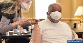 A man being vaccinated by clinician