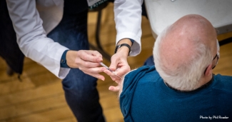 A clinician vaccinates an older man
