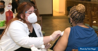 A clinician vaccinates a patient